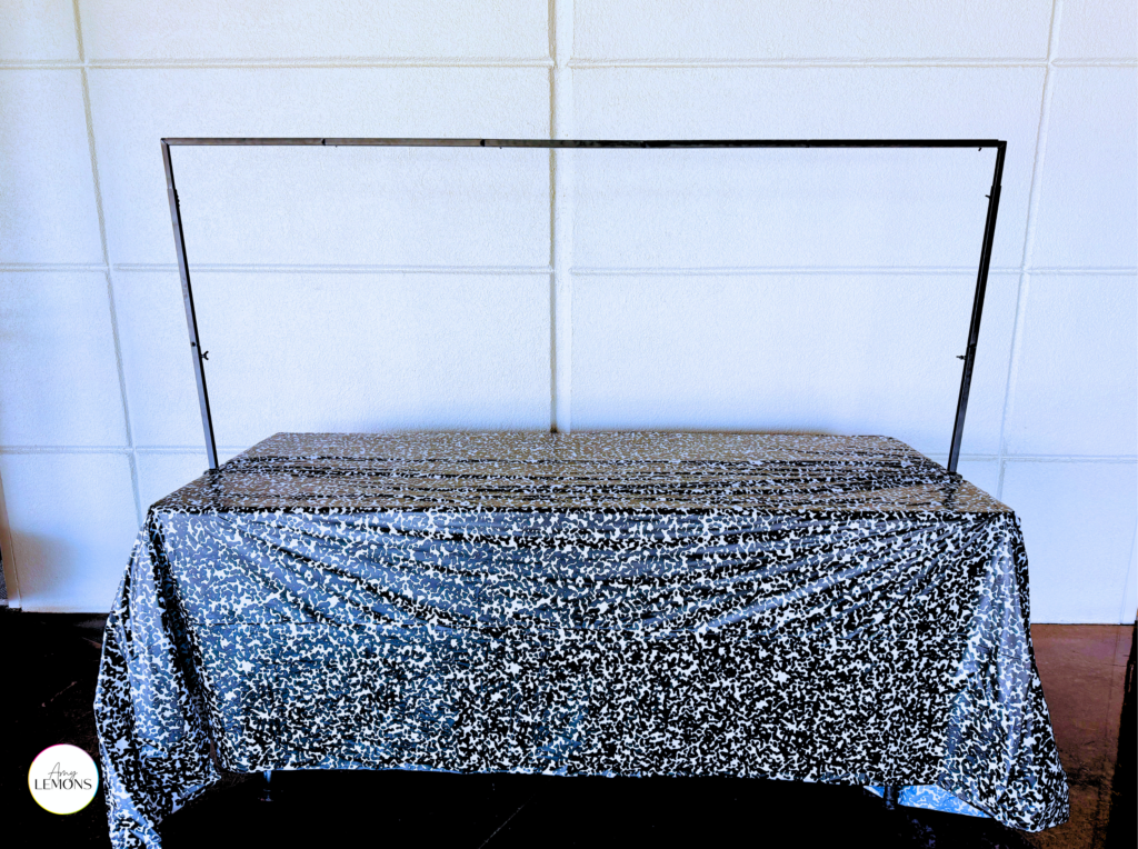 Back to school photo backdrop setup with a blank stand and composition notebook tablecloth