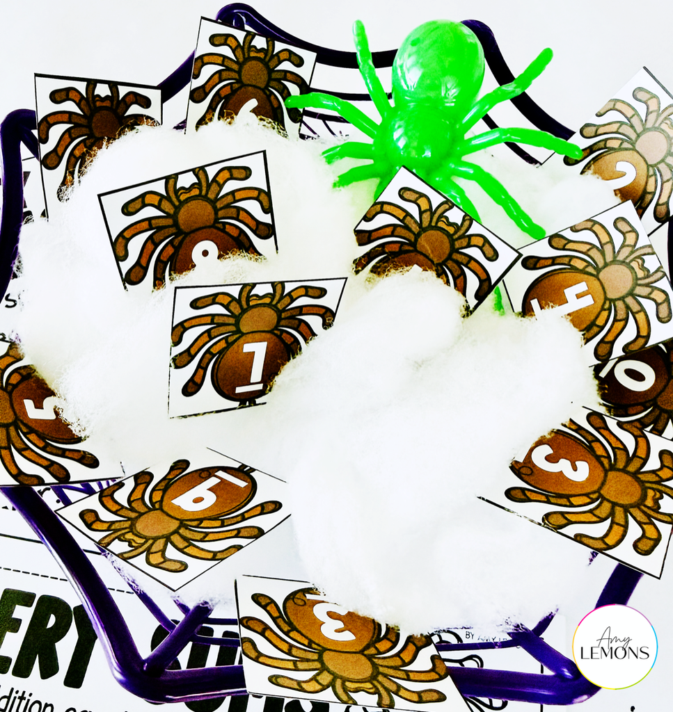 Spider math center with numbered spider cards in cotton webbing inside a purple spider basket, topped with a green plastic spider